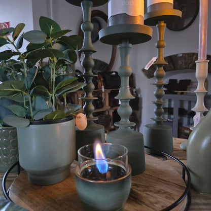 Holztablett mit Kerzenständer und Blumen sowie kleiner Tischkamin von Tenderflame in Grüntönen.