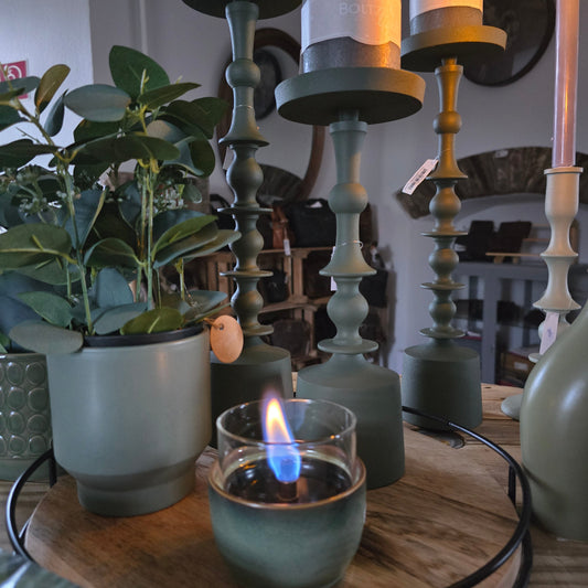 Holztablett mit Kerzenständer und Blumen sowie kleiner Tischkamin von Tenderflame in Grüntönen.